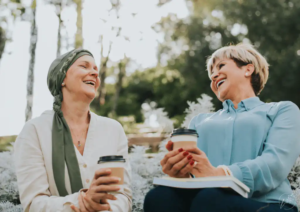 Que dire à un proche touché par la maladie, image d'illustration. Une dame réconforte son amie ou proche touchée par la maladie. Toutes deux sourient et passent un moment positif ensemble.